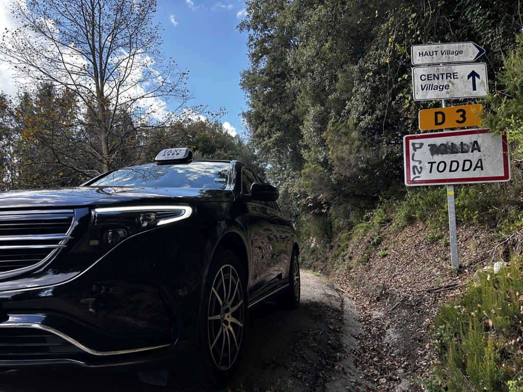 Taxi Tolla devant le panneau du village de Tolla en Corse du Sud